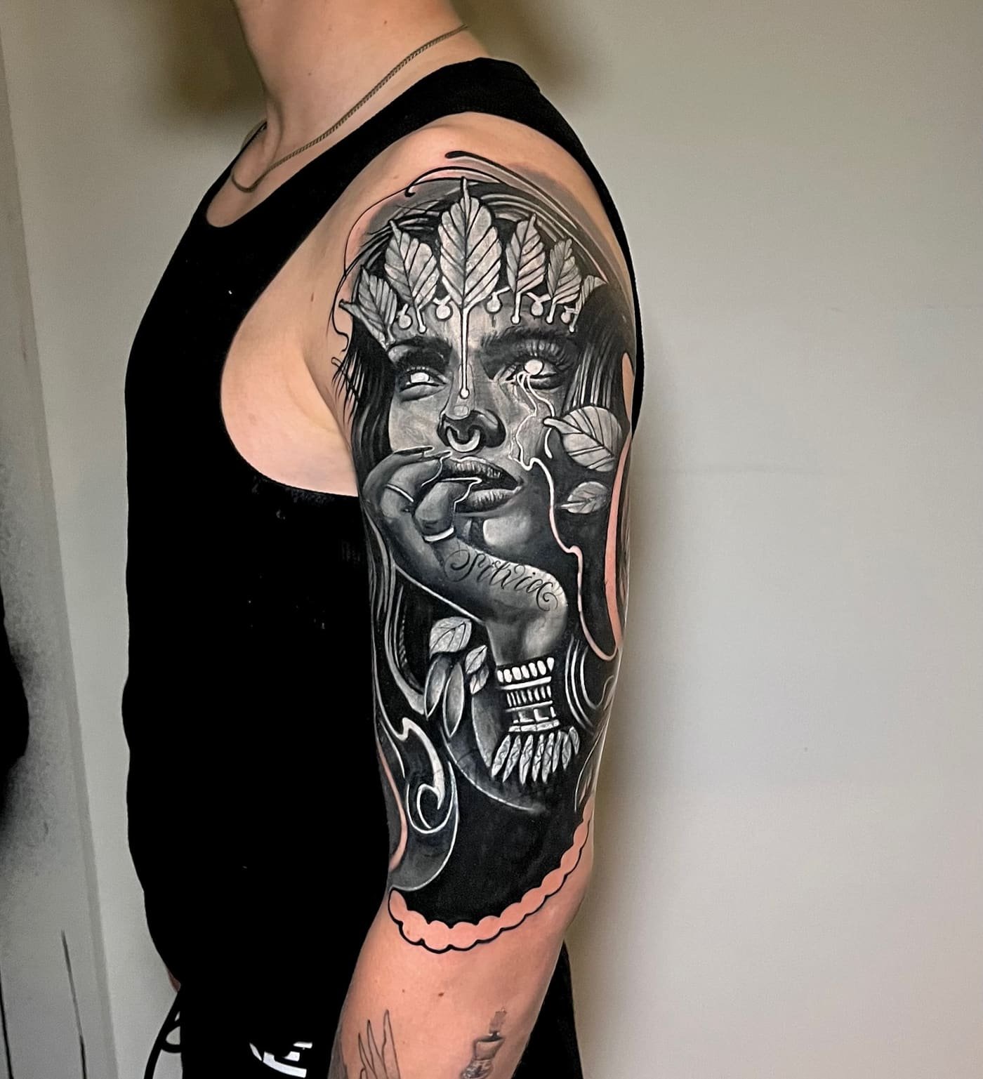 Tatuaggio Black and Grey di un volto femminile con corona di foglie